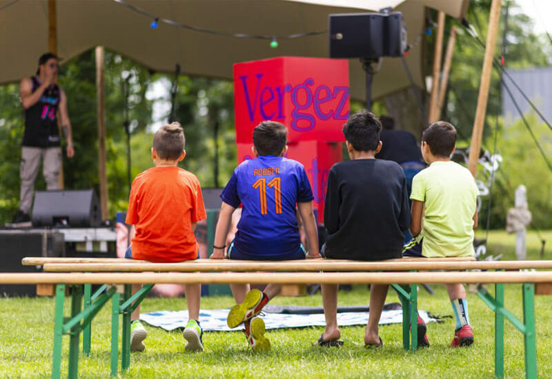 Vier kinderen op een bankje, van achter gefotografeerd, op het Vergezichtenfestival