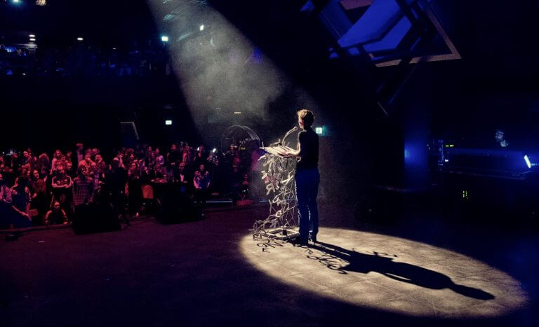 Over ons. Schrijver geeft voordracht voor publiek op Wintertuinfestival in Nijmegen. Foto: Studio Schulte Schultz